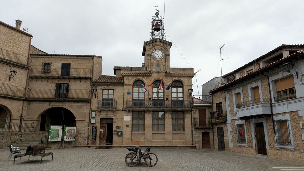 Plaza mayor de Fermoselle con el ayuntamiento de piedra y una bicicleta cargada en primer plano