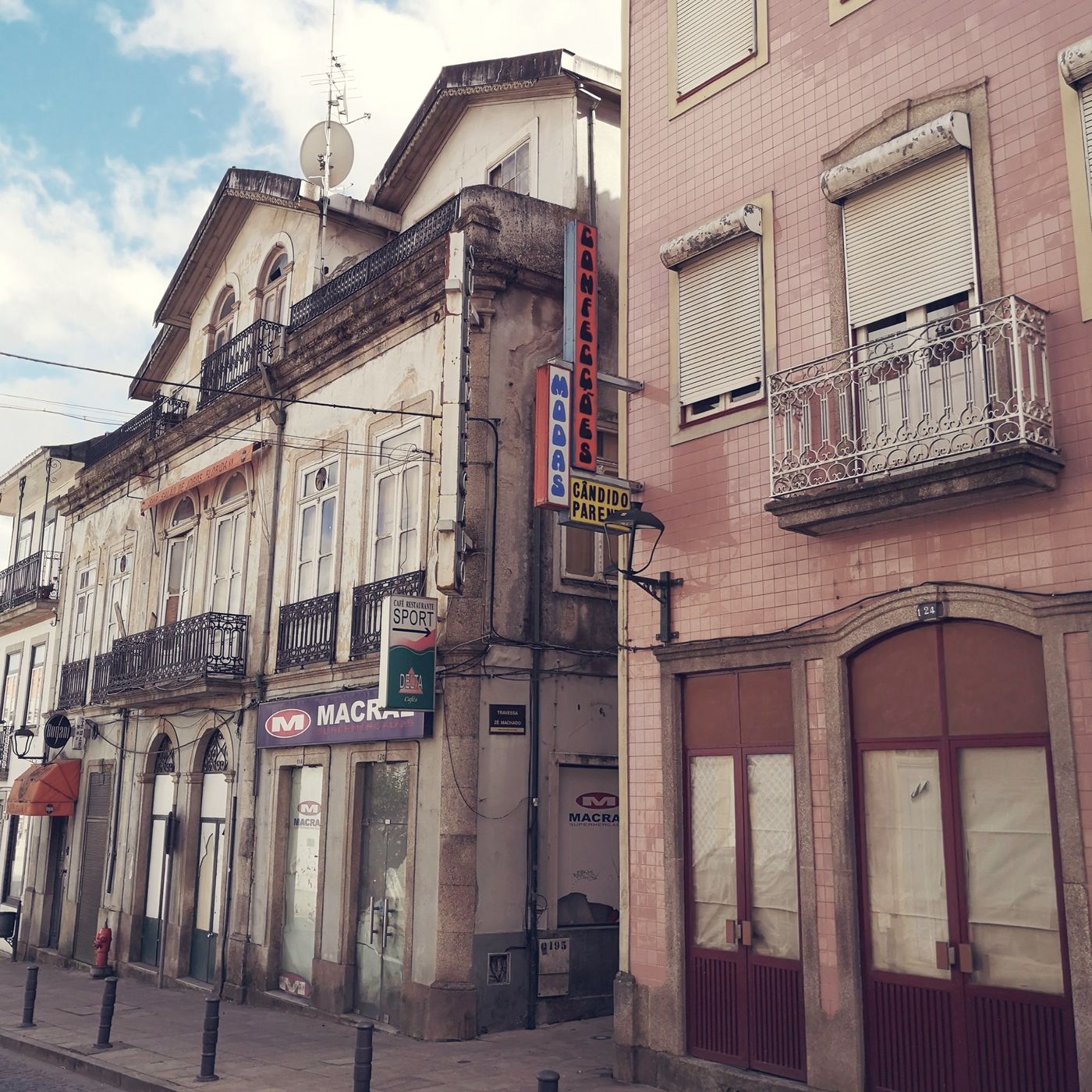 Calle de Bragança con fachadas antiguas, balcones de hierro y letreros de comercios